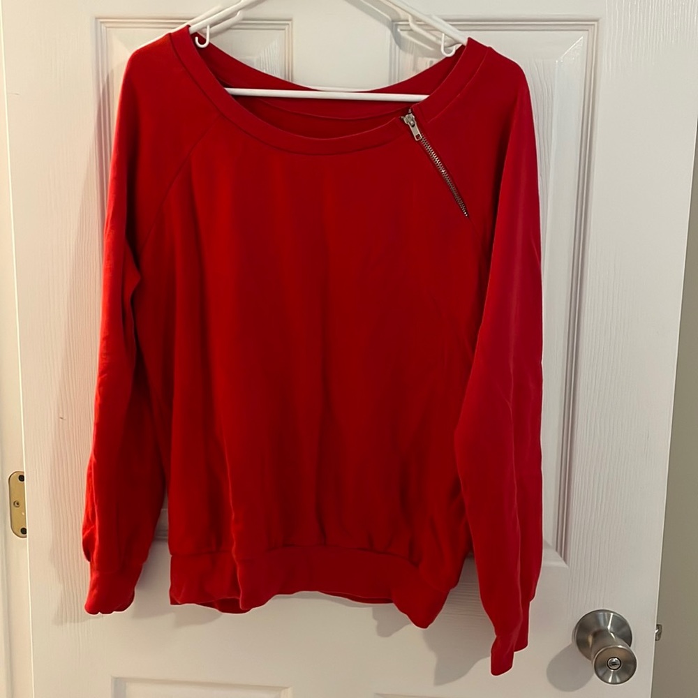 Red pull over sweater with zipper on the side.